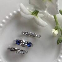 3 stone ring with sapphires and bands on dish BG