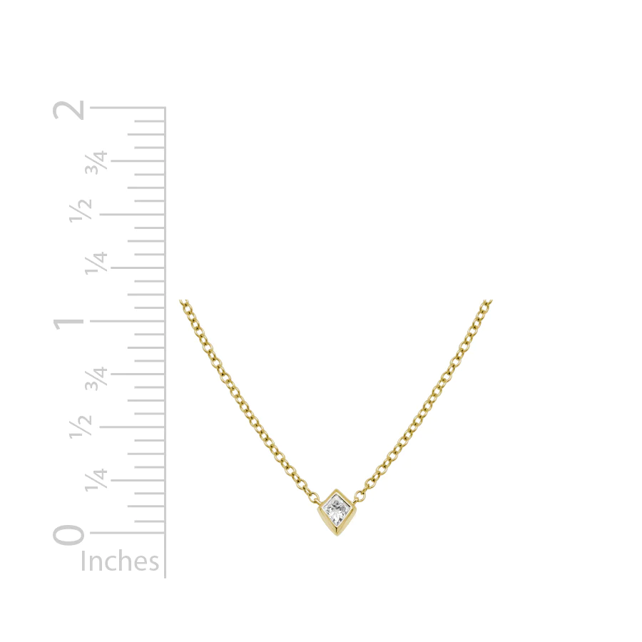 kite shaped diamond bezel necklace 14k yellow gold with a ruler for scale
