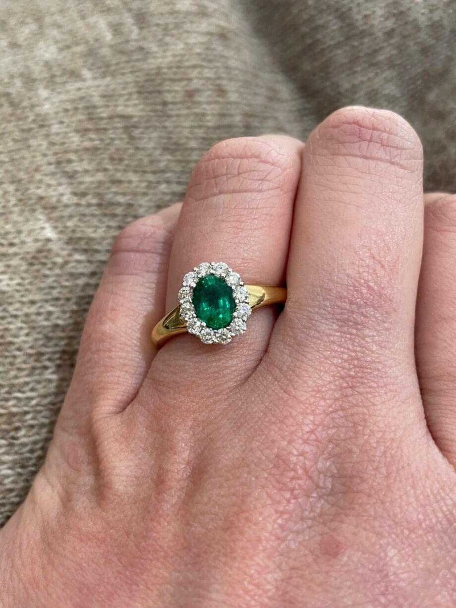 Oval emerald halo ring in 18K two-tone gold with yellow gold band and diamonds, size 6.5.