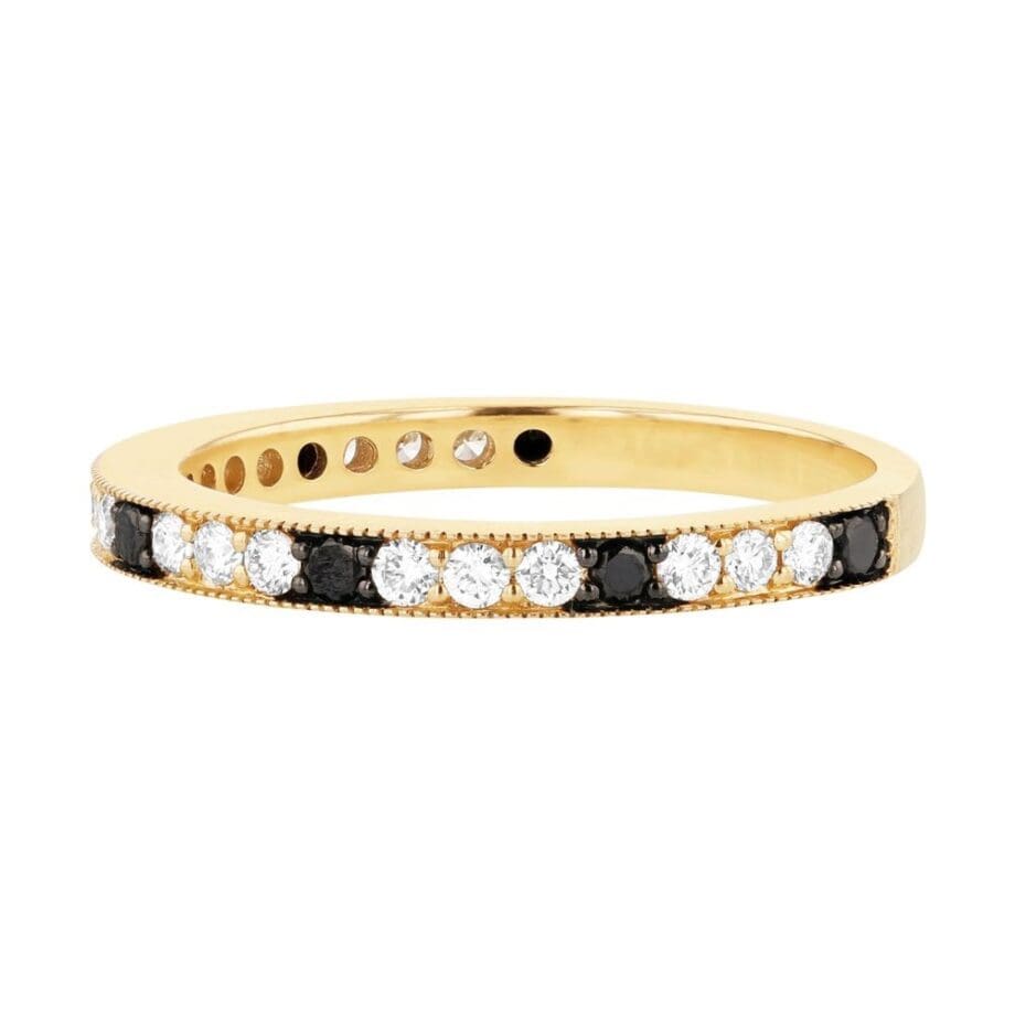 14K yellow gold diamond band with alternating white and black diamonds in a shared prong setting, detailed with milgrain edging. side view