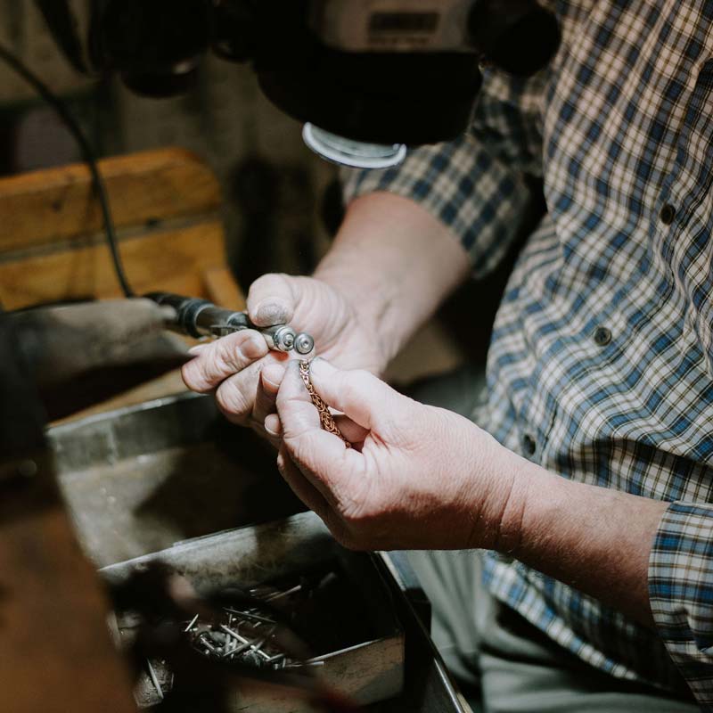 Hands shown of jeweler making a jewelry repair