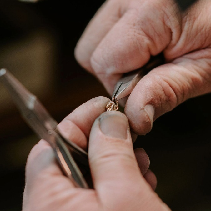 Jeweler's hands working on a chain repair and clasp replacement