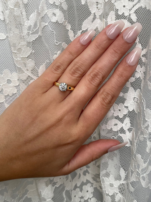 Round diamond solitaire engagement ring in 18K yellow gold band with platinum diamond setting