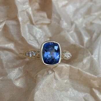 Blue Sapphire Concerto Ring featuring a blue sapphire and elongated cushion cut gemstone accents set in 18K yellow gold, size 6.5