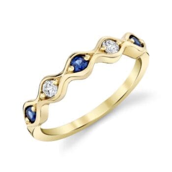Anniversary ring with a blue sapphire center and round diamond accents set in 14K yellow gold