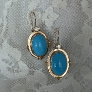 Turquoise earrings with robin egg blue center gemstones set in 14K yellow gold featuring French wire backs