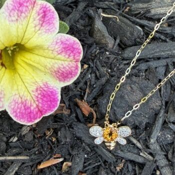 14K yellow gold bee pendant with a round orange citrine gemstone and diamond accents
