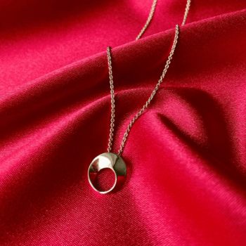 Mobius Pendant featuring a twisted loop design in warm 14K yellow gold