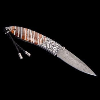 Jackson Monarch folding knife featuring hand-engraved stainless steel frame and fossil Woolly Mammoth tooth handle with damascus steel blade