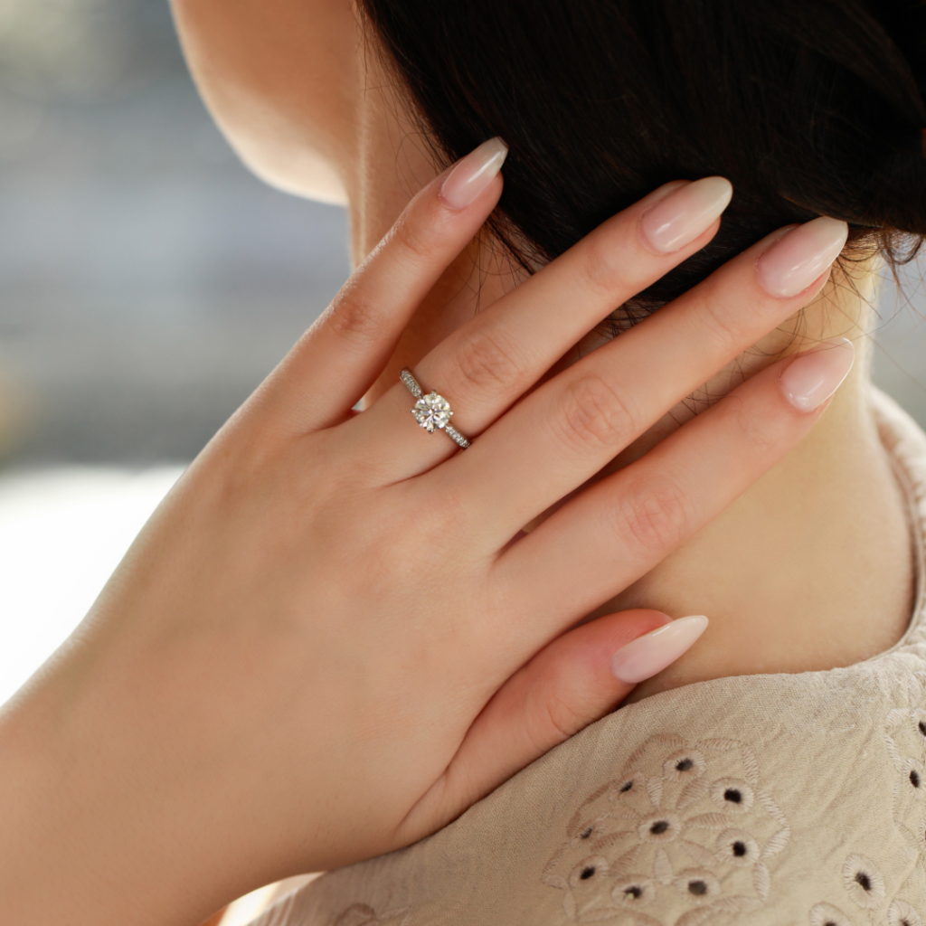 Woman with hand on back of neck with diamond ring that has been resized