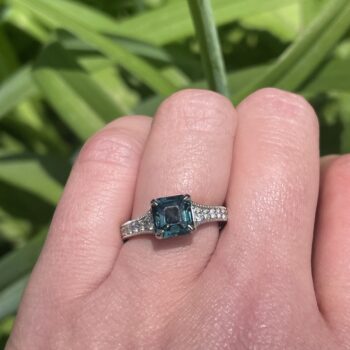 Teal sapphire engagement ring in platinum with 22 hexagonal diamond accents