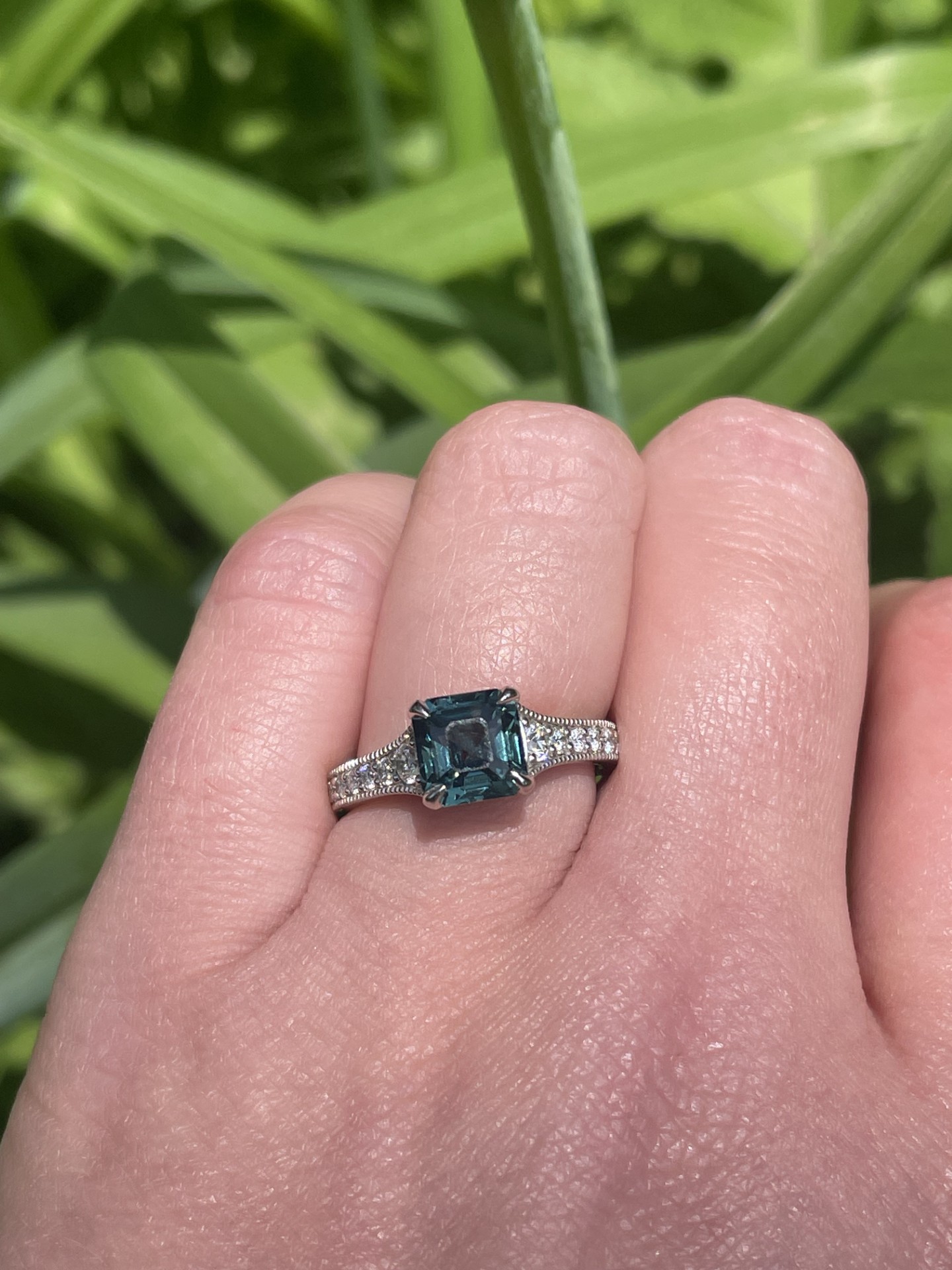 Teal sapphire engagement ring in platinum with 22 hexagonal diamond accents