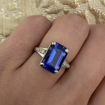 Tanzanite ring New Horizon with deep purple emerald cut center and emerald cut side gemstones set in platinum