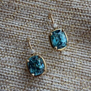 Teal blue elongated cushion cut zircon earrings set in 14K yellow gold with diamond accents and French wire closures