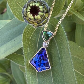 Bezel kite pendant featuring tanzanite and tsavorite gemstones in 14K yellow gold with diamond accents